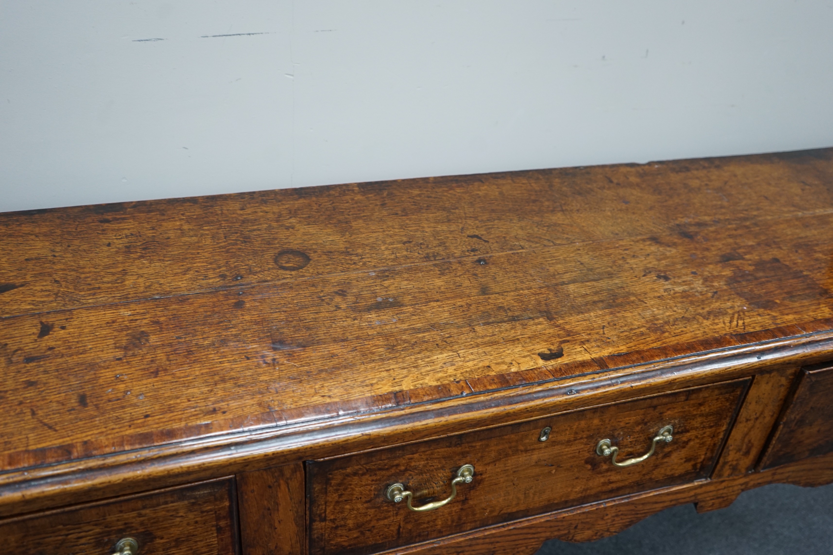 A George III provincial oak and mahogany banded low dresser with three drawers on square tapering legs, width 201cm, depth 46cm, height 83cm